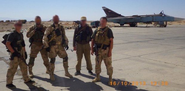 Personal de Slavonic Corps en Siria con un avión de ataque Su-24 a sus espaldas.